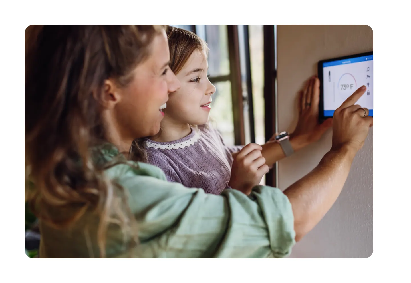 Mom and daughter using thermostat