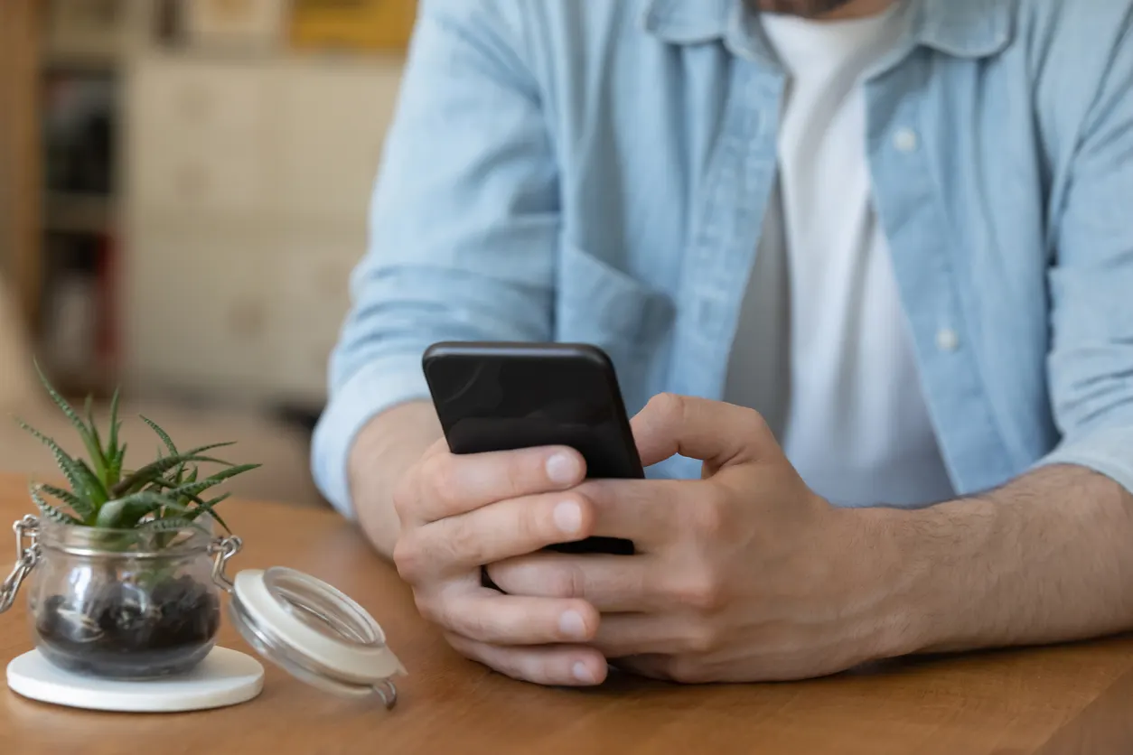 Close up young man holding electronic device in hands.