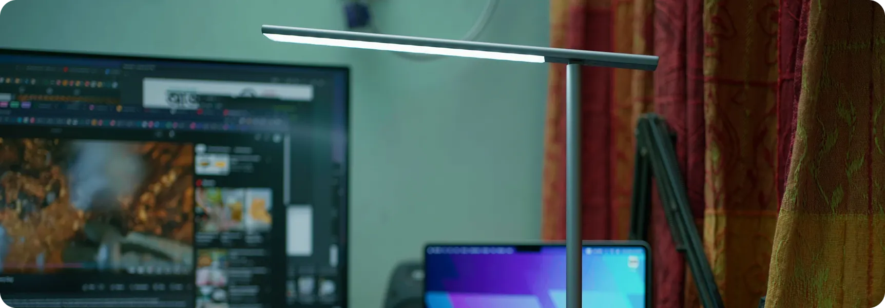 Modern desk lamp illuminating a computer workstation setup