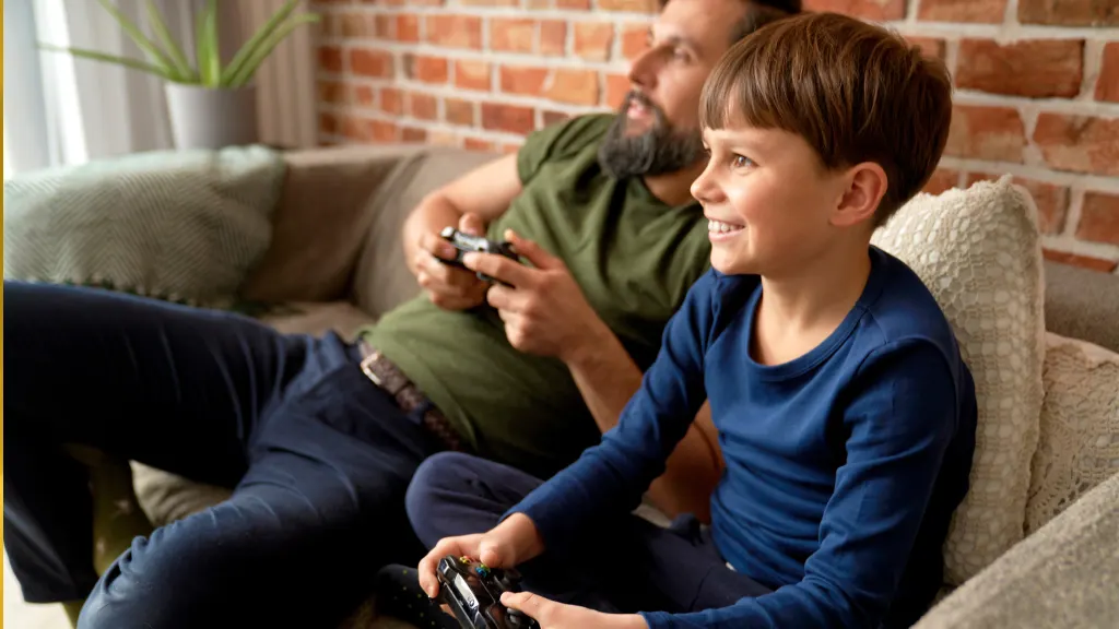 Image of father and son on a couch with Playstation controllers