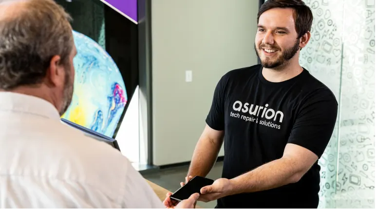 An Asurion expert helping a customer with his phone in-store