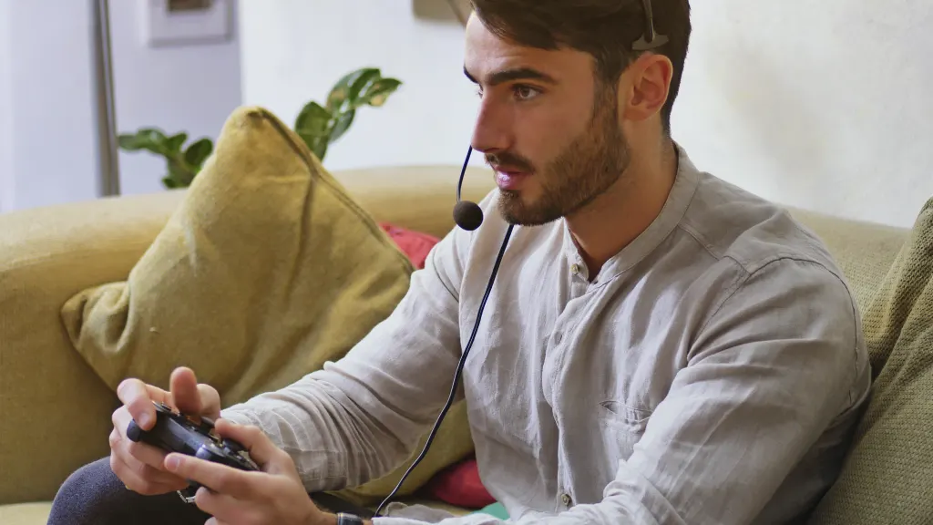 Lifestyle image of yound man gaming with a controller and headset