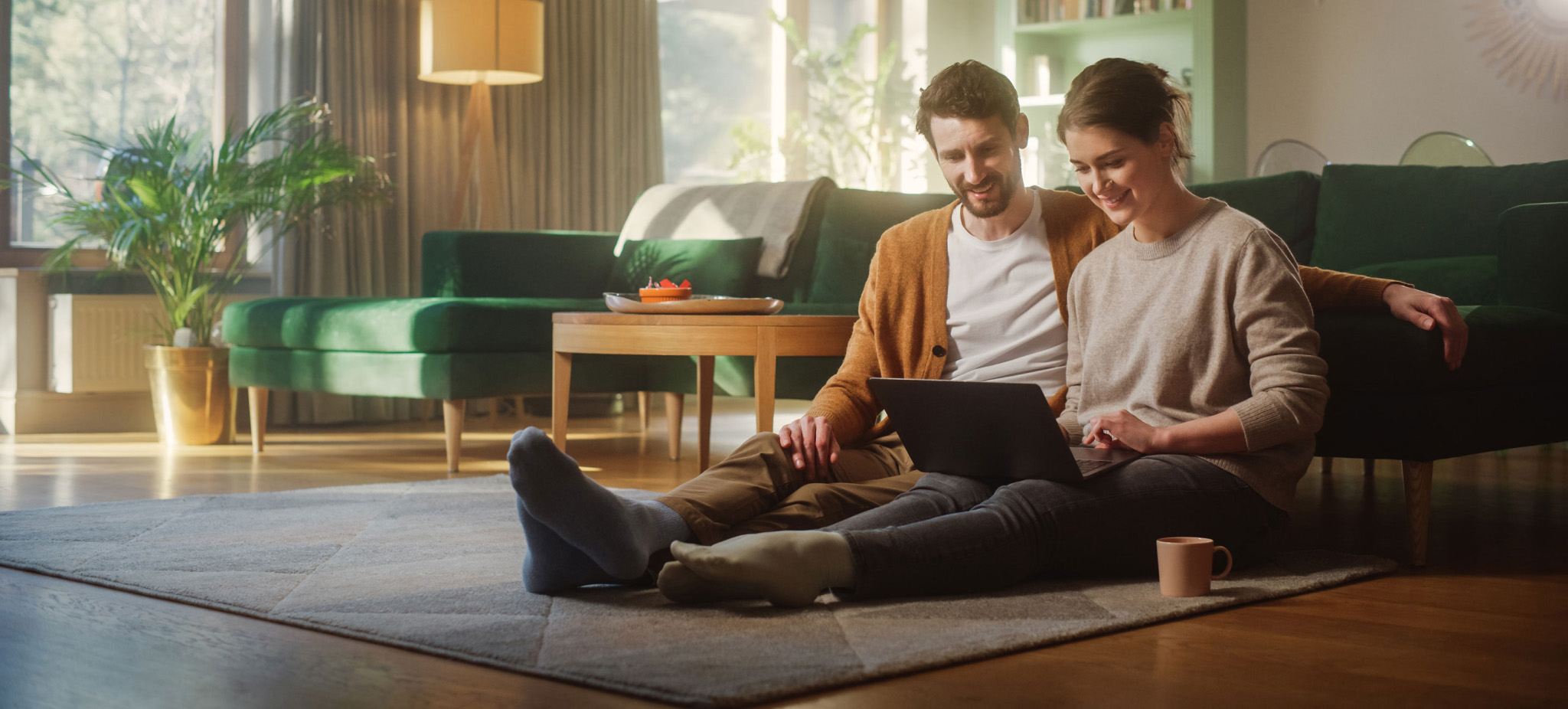 a couple looking at laptop in living room