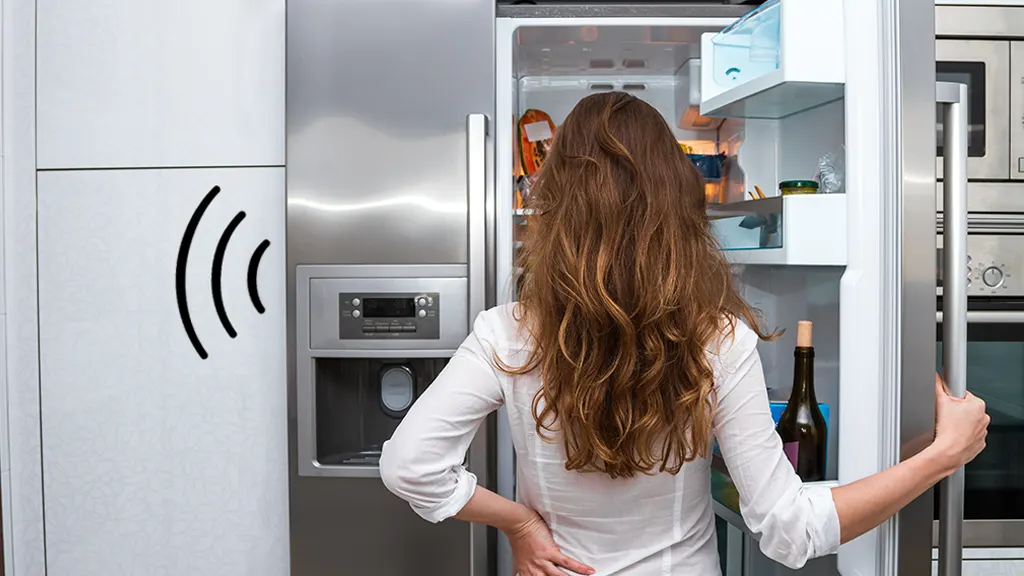 Woman looking inside noisy refrigerator