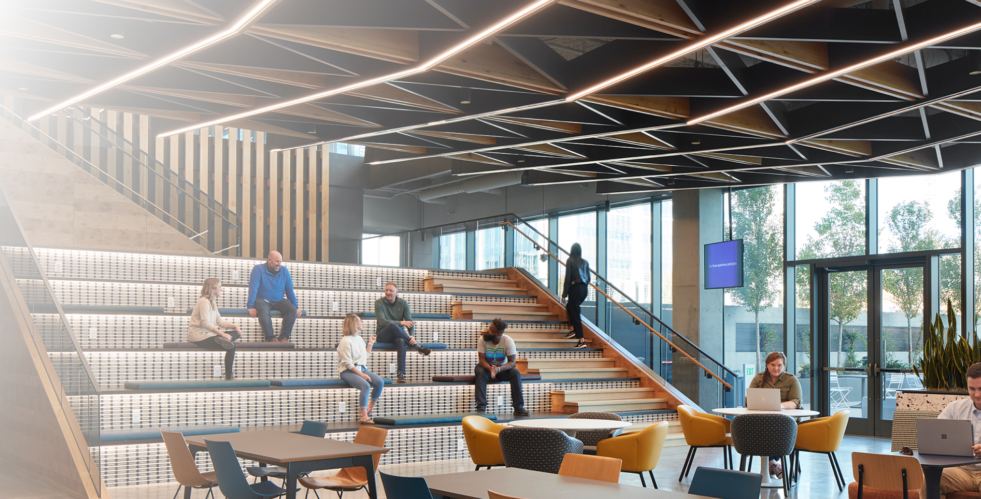 Employees sitting on steps in common area of Gulch Hub