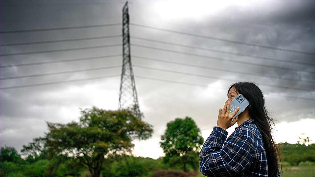 Woman holding cell phone during bad weather 