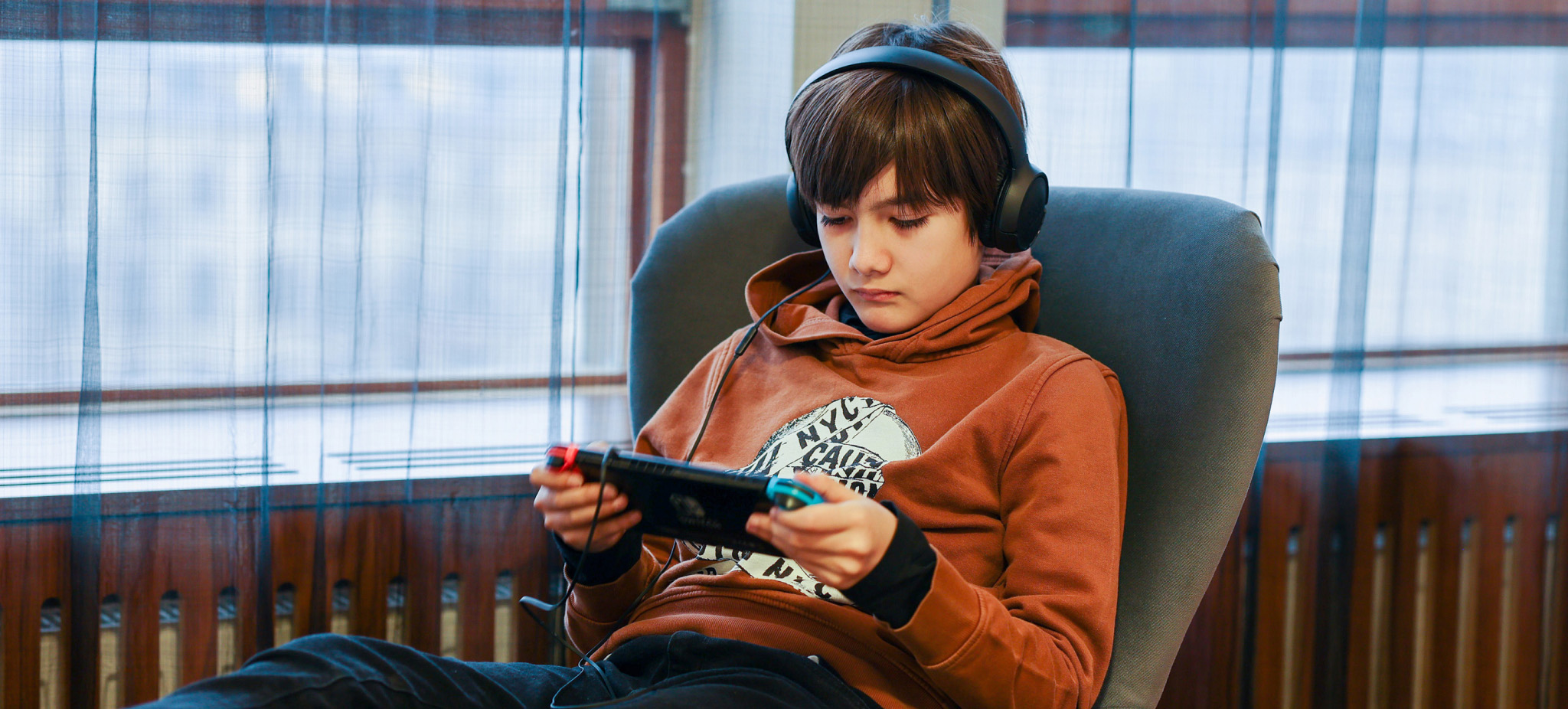 A teenager playing Nintendo Switch