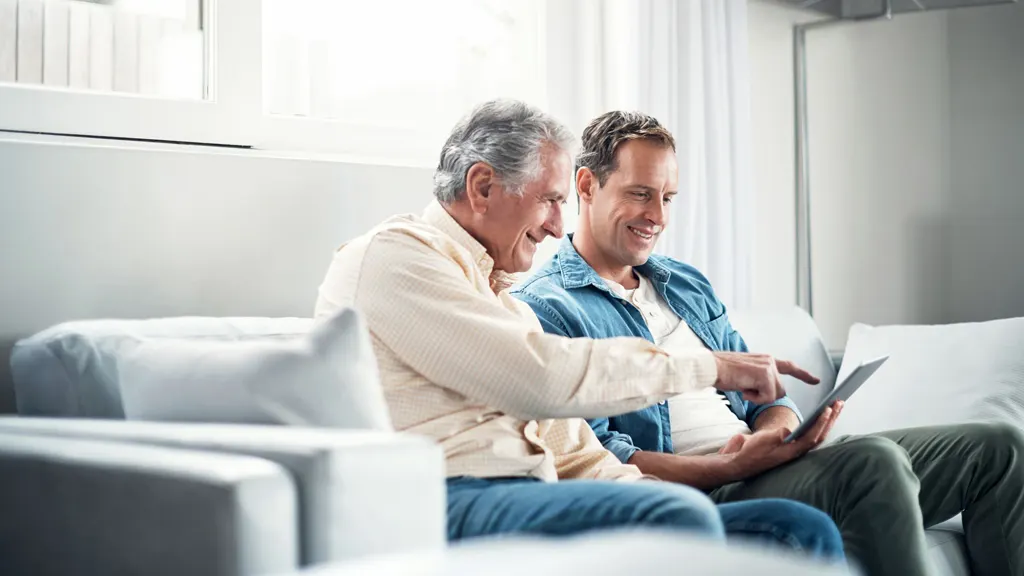 Father and son sitting on couch using iPad shortcuts