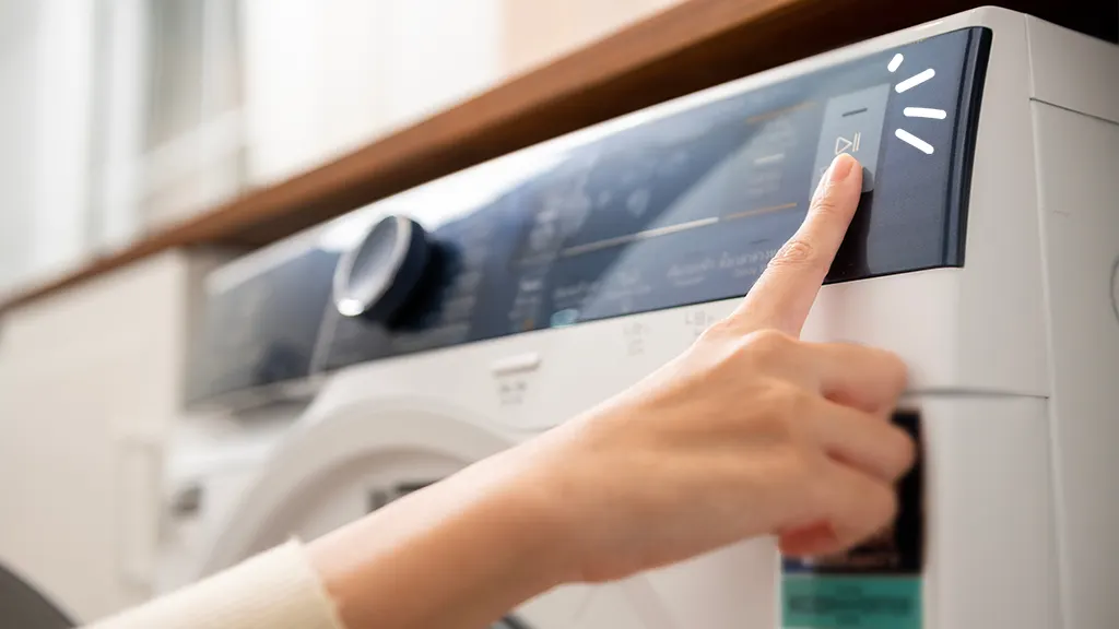 Person touching start button on washer that suddenly stopped working