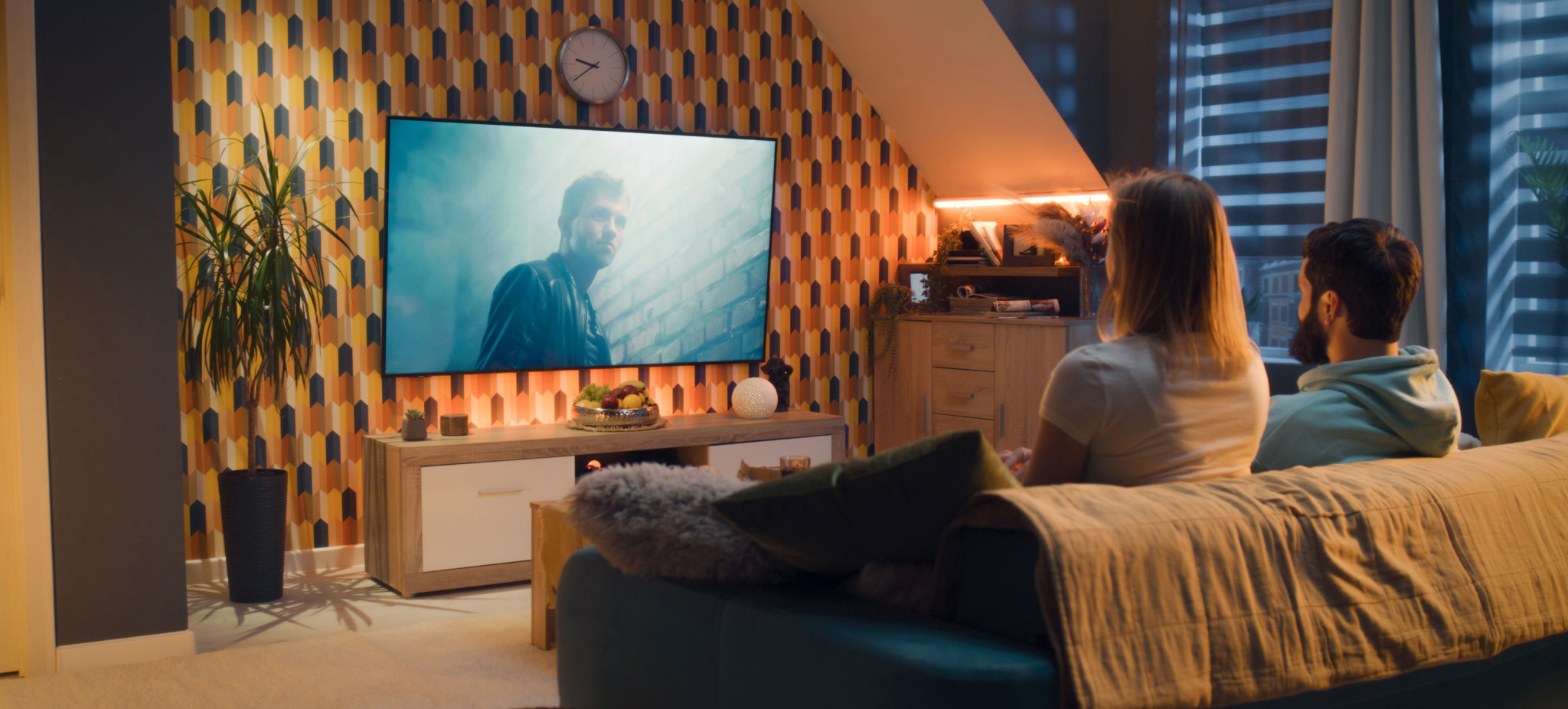 Family sitting on couch watching TV