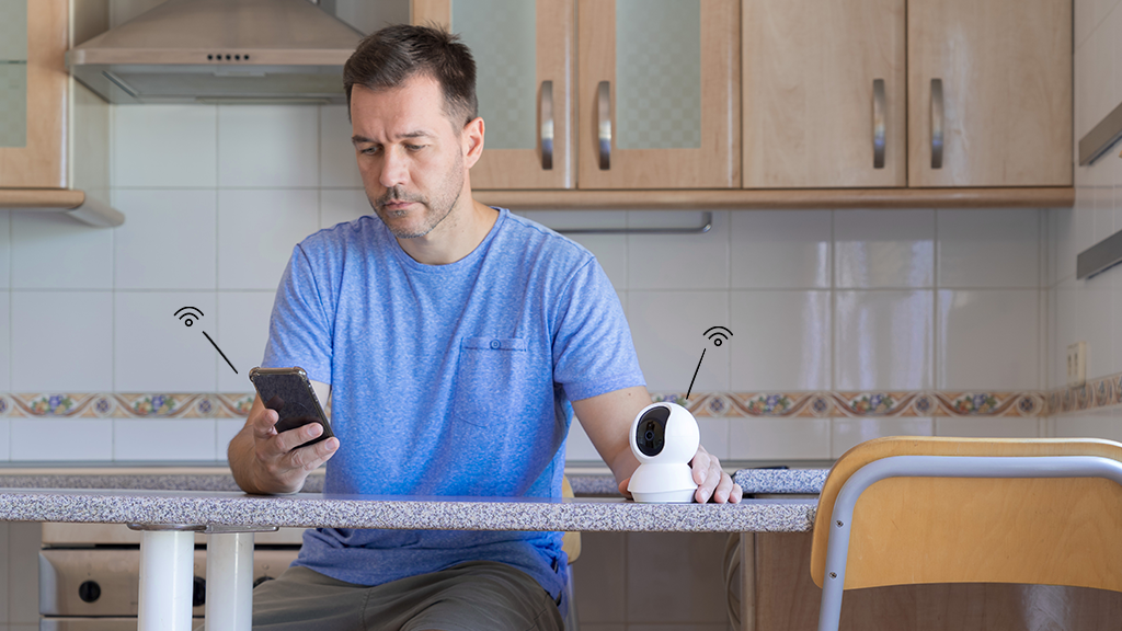 Man looking a this phone while setting up his smart home devices 