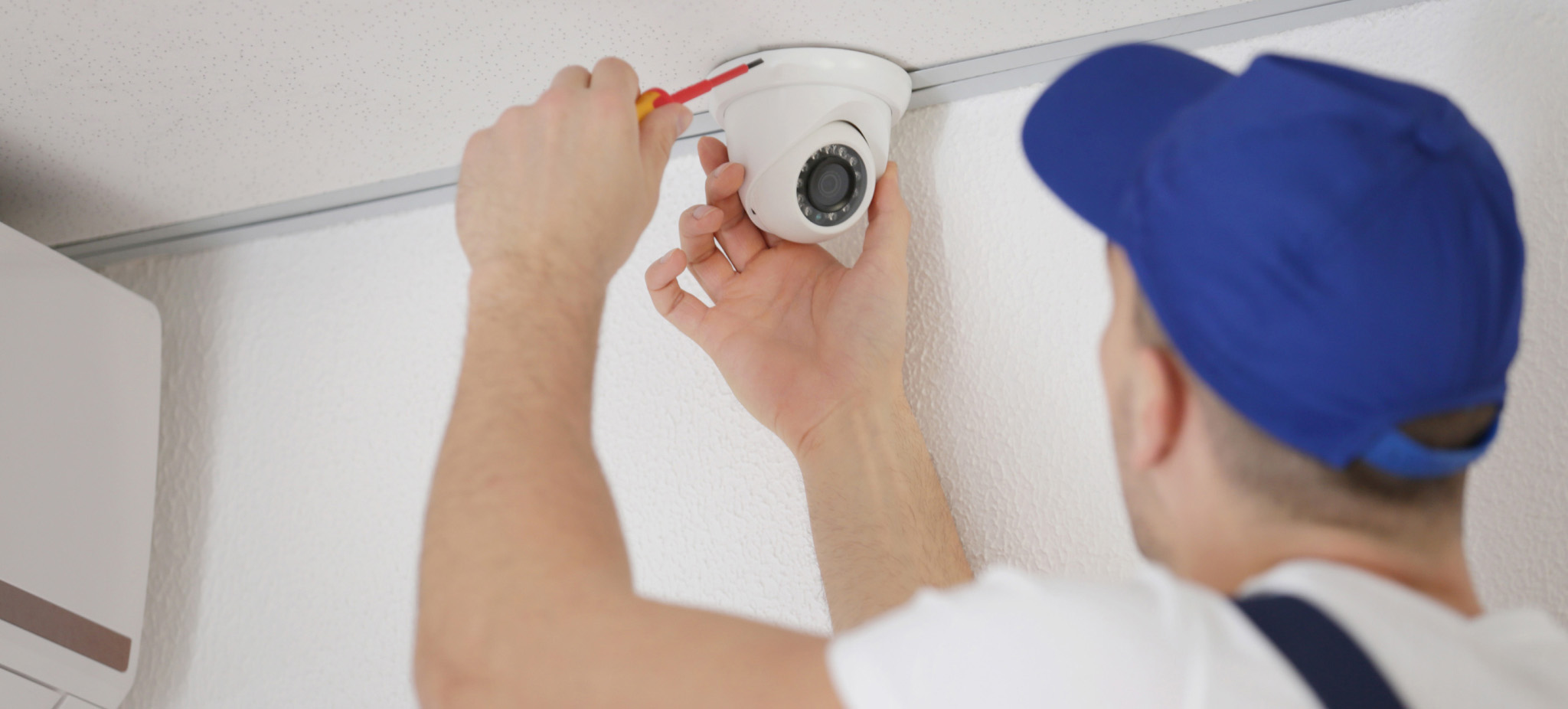 Man mounting indoor security camera 