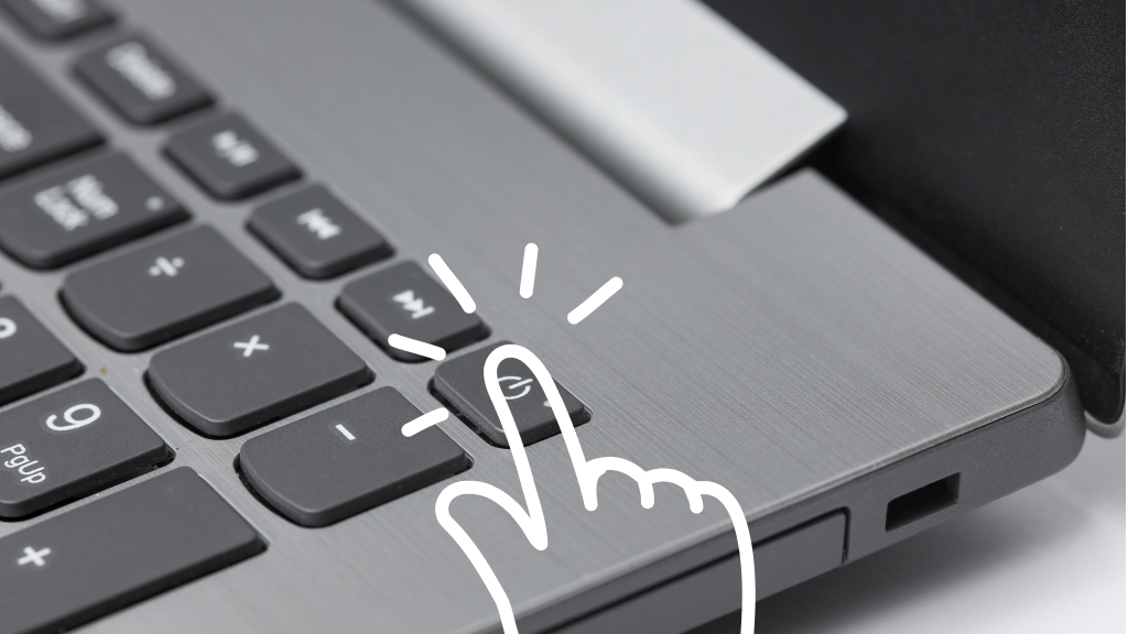 Close up of laptop keyboard with illustration of finger pressing power button.