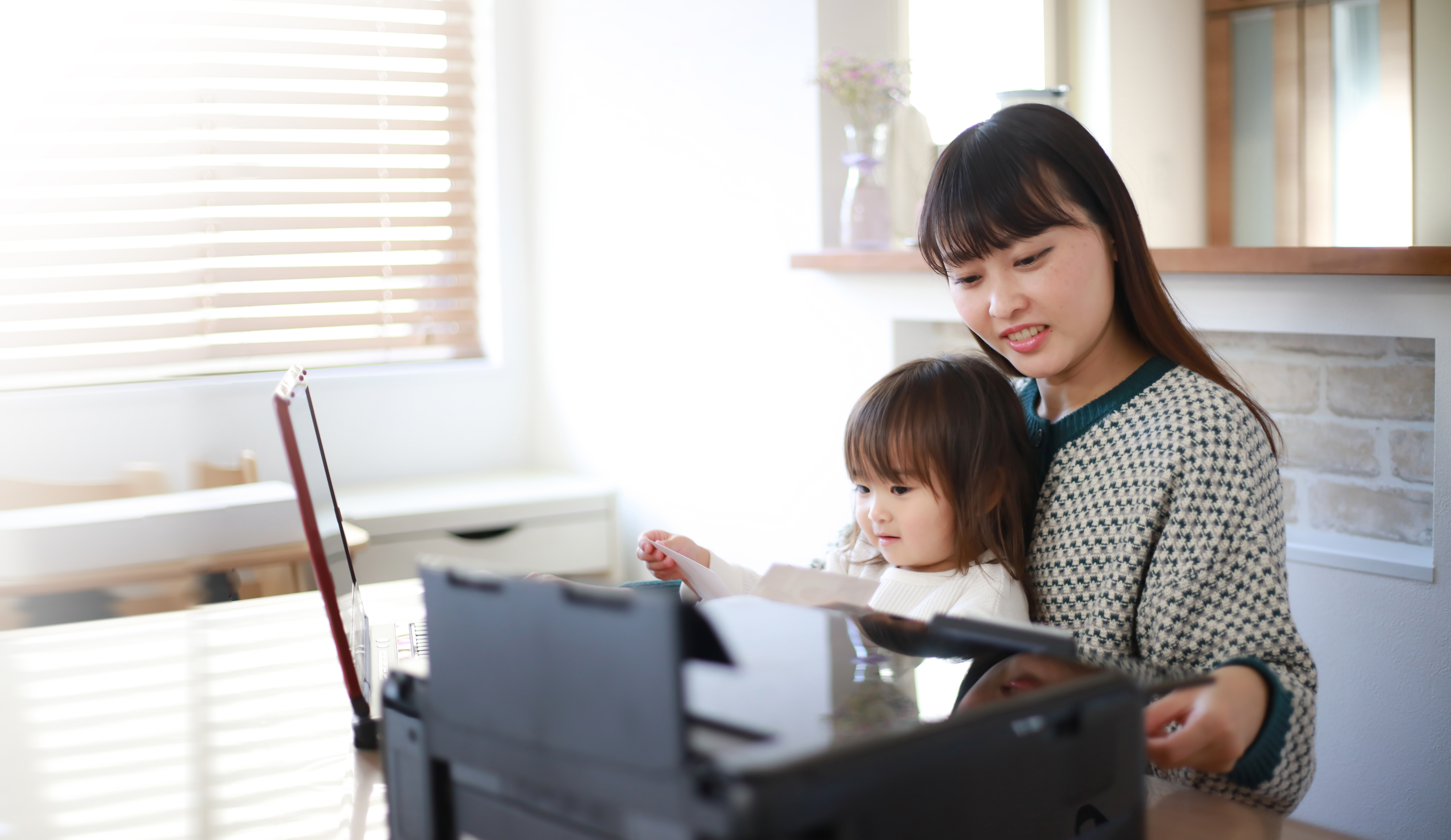 mom and daughter in home office room with printer