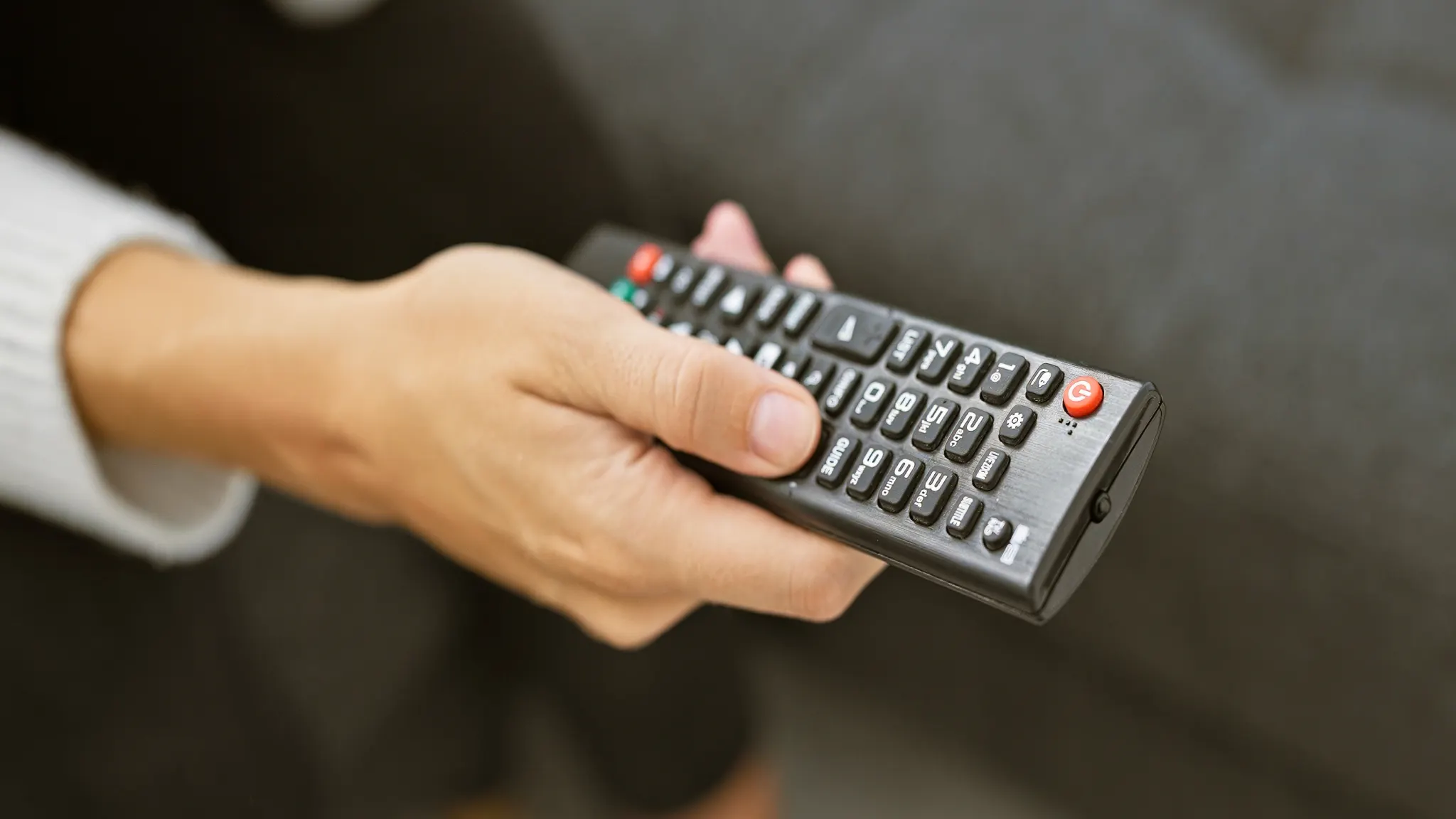 DISH TV remote with television, illustrating how to program and pair the remote using a code or on-screen setup