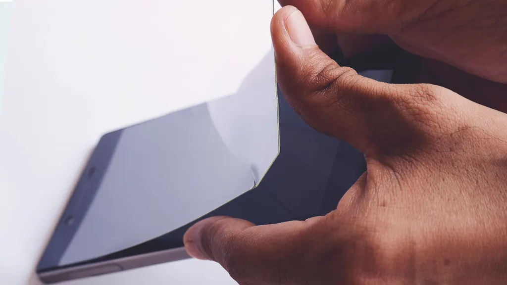 Plastic or glass screen protector being removed from phone