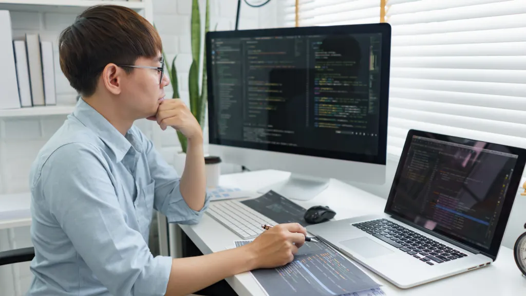 Man using Mac with dual monitors