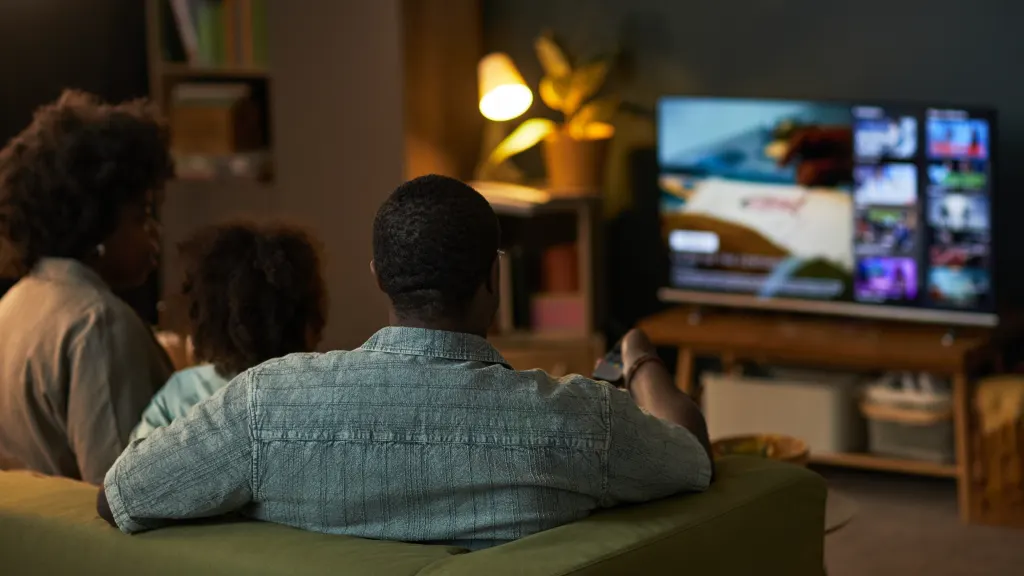 Lifestyle image of a family watching TV on a couch