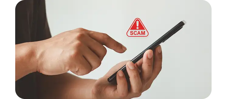 Person using a smartphone with a scam alert icon, highlighting phishing scams, fraudulent messages, and mobile security awareness.