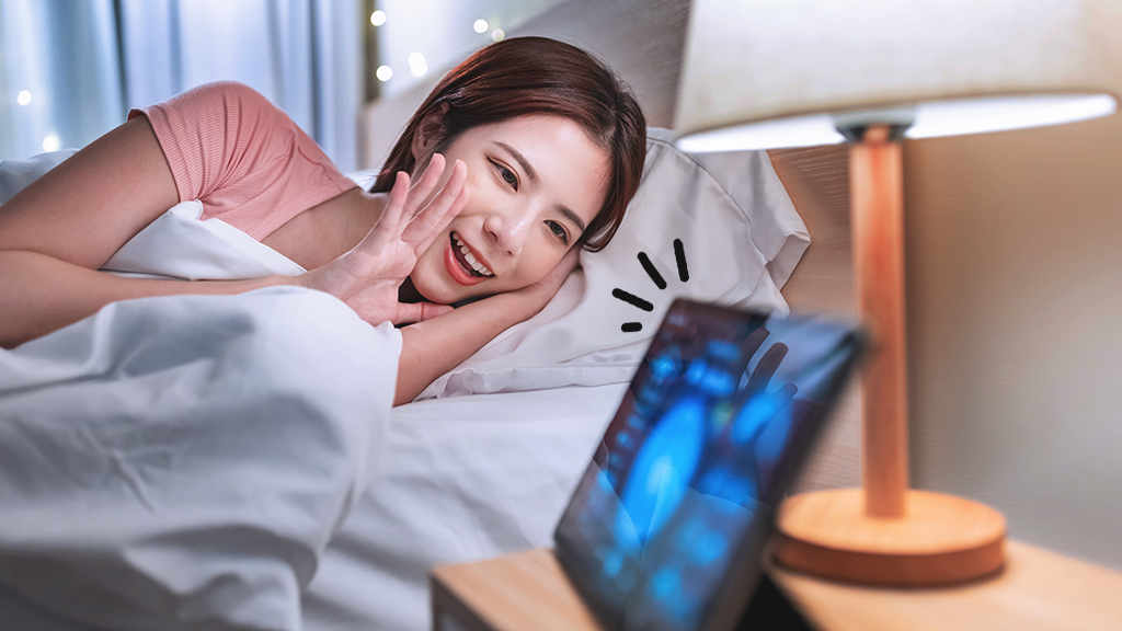 Woman talking to Smart Home display in bed