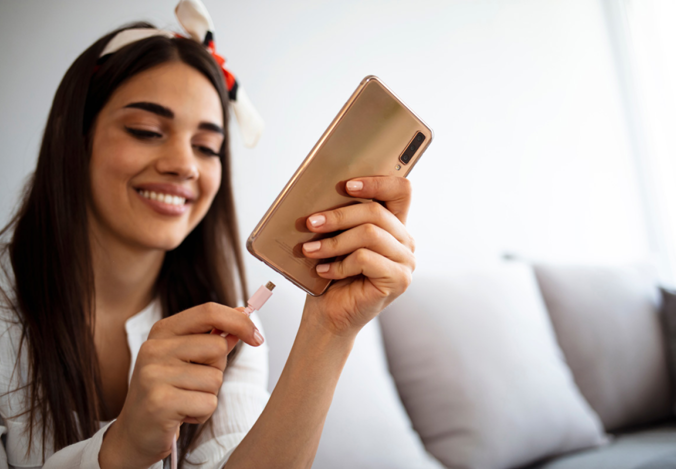 A young woman inserting a charger into a mobile phone