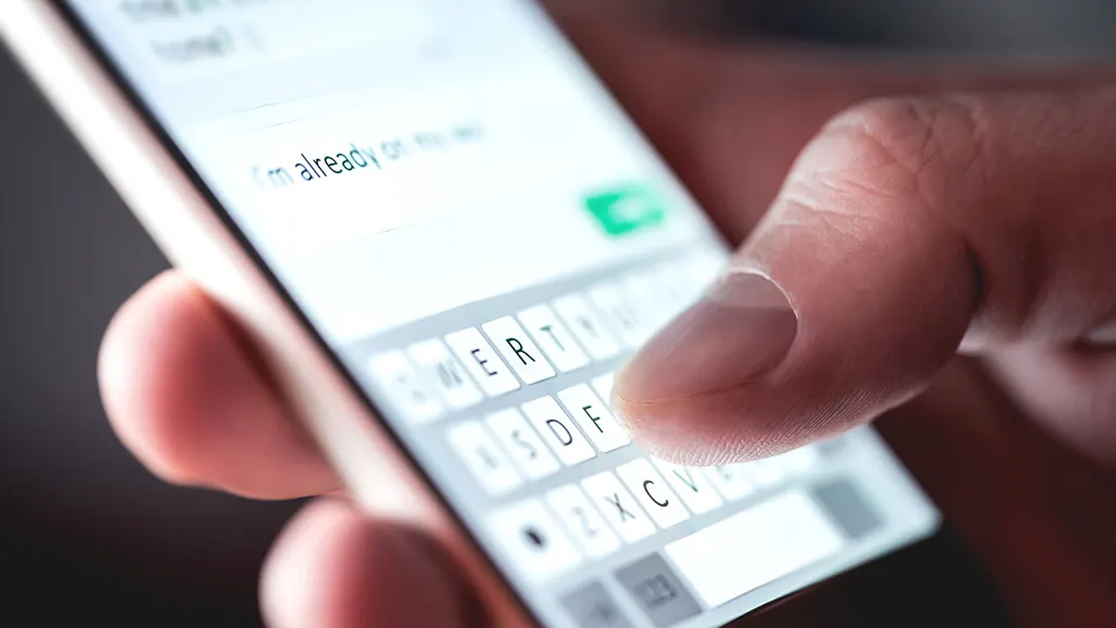 Close-up of person texting on iPhone