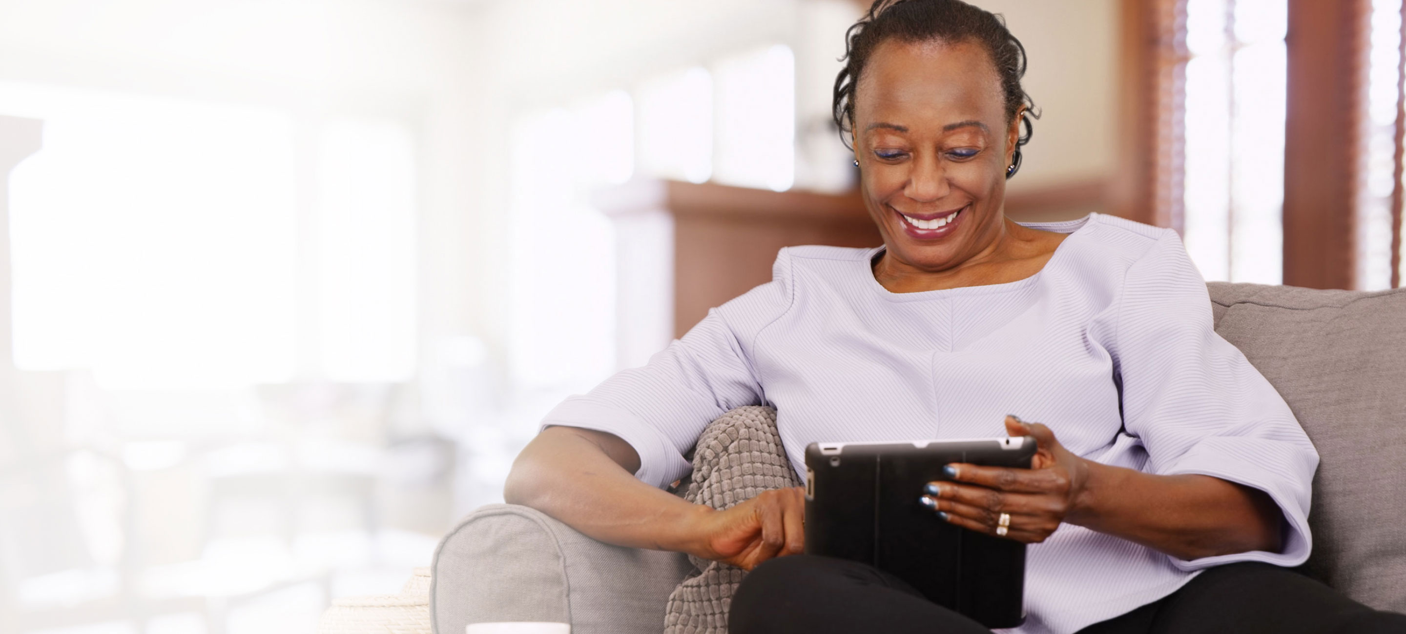 Woman reading her tablet on the coach