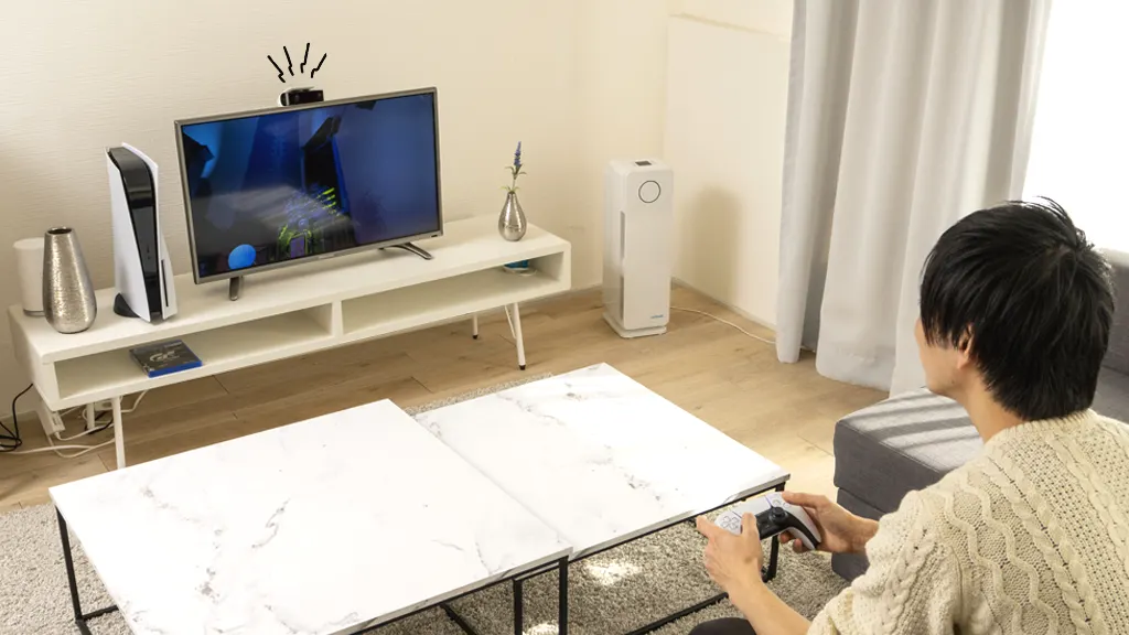 Person playing PlayStation 5 in living room with PS5 camera that won't connect