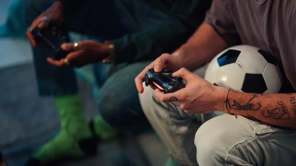 Close-up of two men holding Playstation 5 controllers