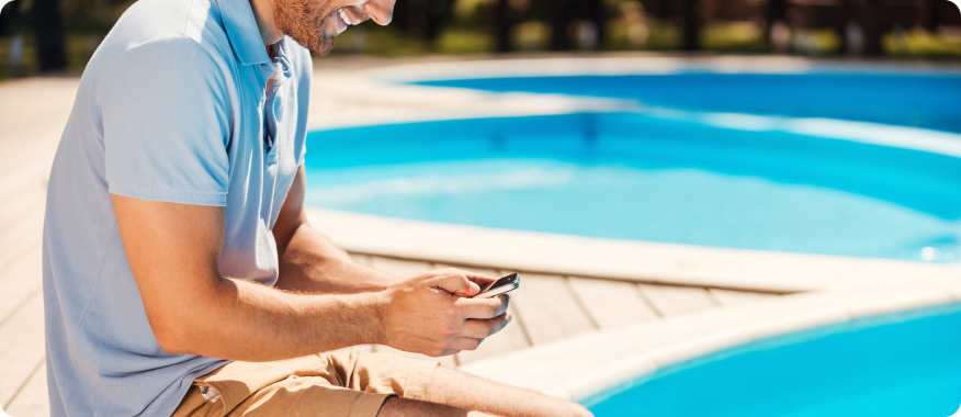 Sitting by pool using phone