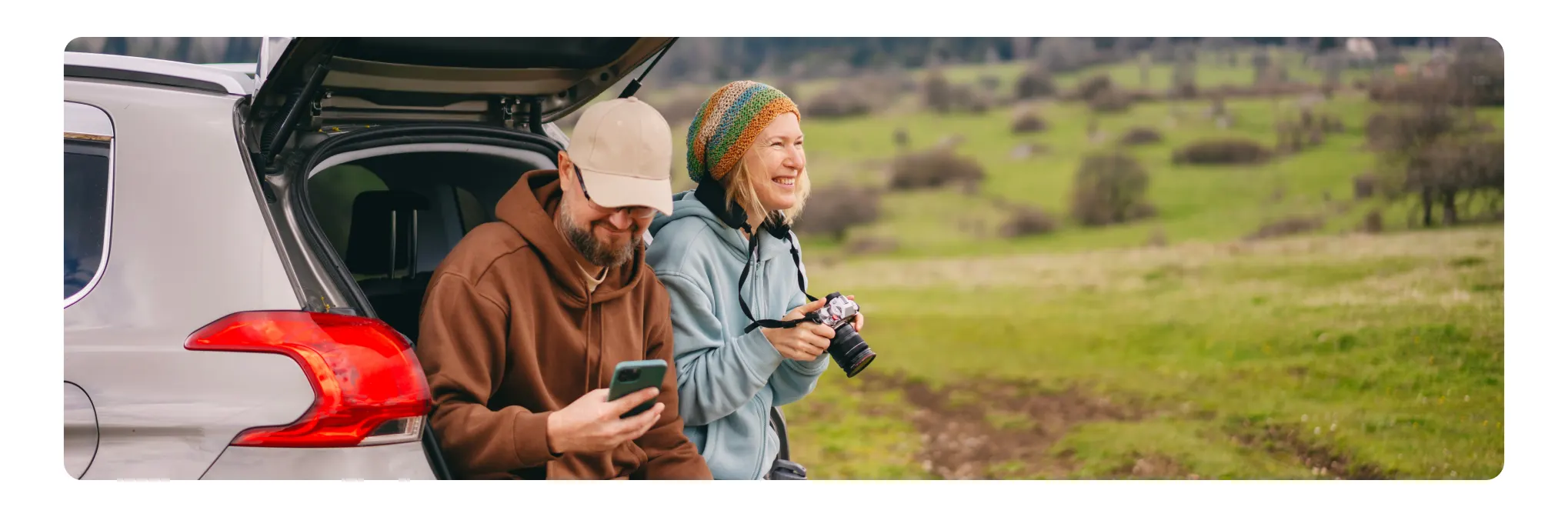 Couple sitting in back of car in fall