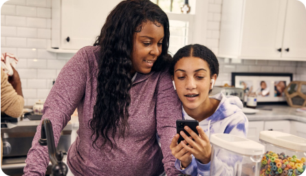 Mom and daughter using phone in the kitchen