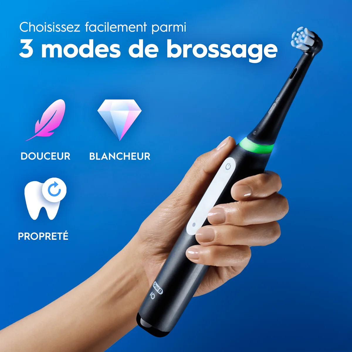 Brosse à dents électrique rose tenue en main, avec trois modes de brossage (Douceur, Blancheur, Propreté) et leurs icônes sur fond bleu.