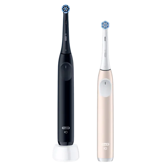 Oral-B iO, deux brosses à dents électriques, une noire sur son chargeur et une rose dorée.