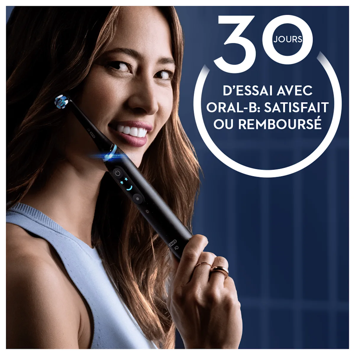 Sourire éclatant d'une femme tenant une brosse à dents Oral-B iO, mise en avant de l'offre "30 jours d'essai : satisfait ou remboursé".