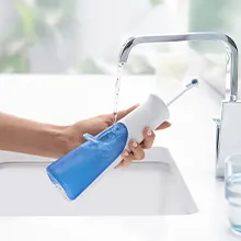 Main tenant l’AquaCare Série 4 au-dessus de l’évier et du réservoir d’eau de remplissage.		 