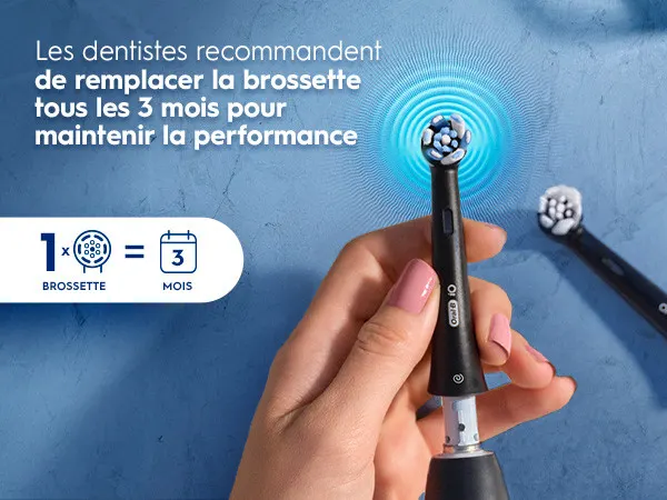 Main tenant une brosse à dents électrique avec conseil de remplacer la brossette tous les 3 mois.