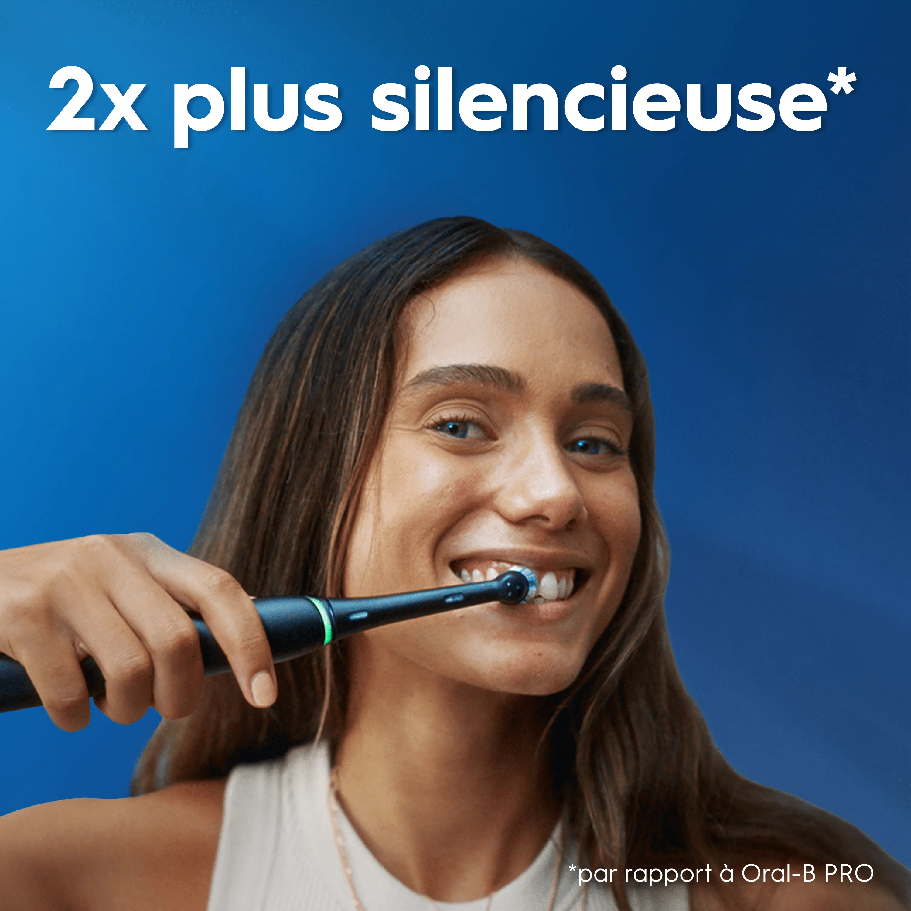 Personne utilisant une brosse à dents électrique avec texte "2x plus silencieuse* *par rapport à Oral-B PRO" sur fond bleu.