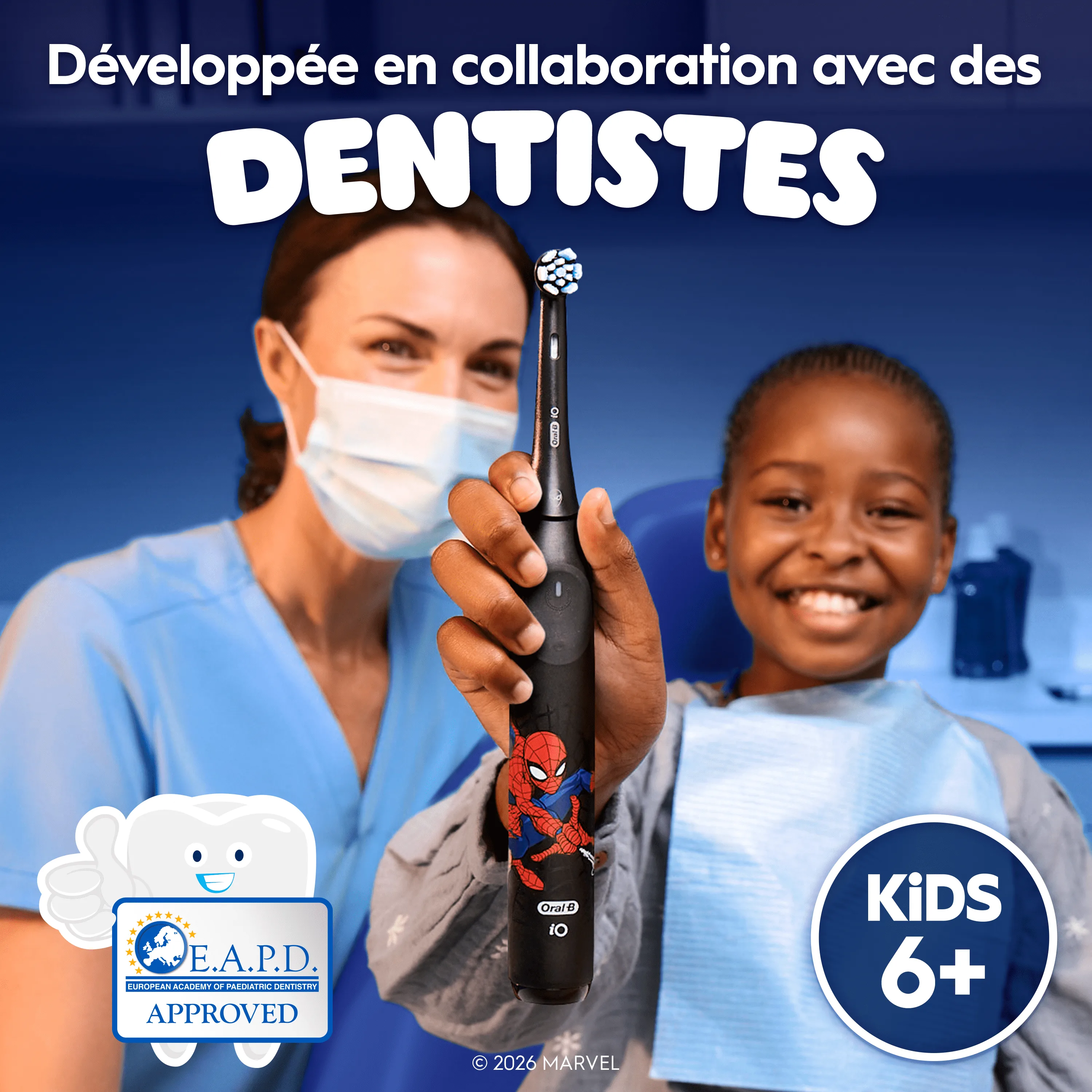 Un dentiste et un enfant tenant une brosse à dents iO Kids 6+, conçue avec des dentistes.