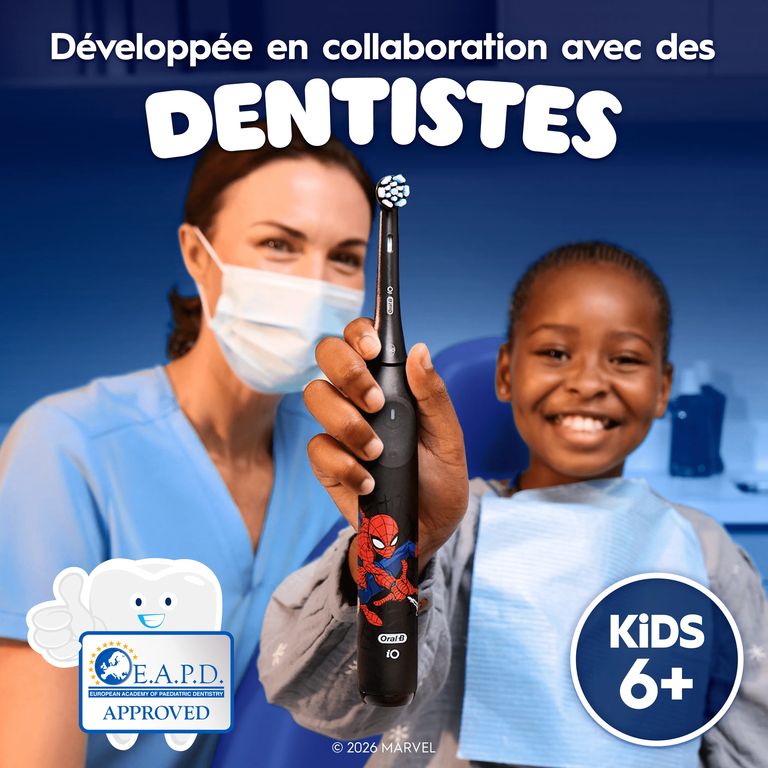 Présence du logo EAPD. Un enfant souriant assis sur une chaise de dentiste utilisant iO Kids 6+ à côté d’un dentiste.