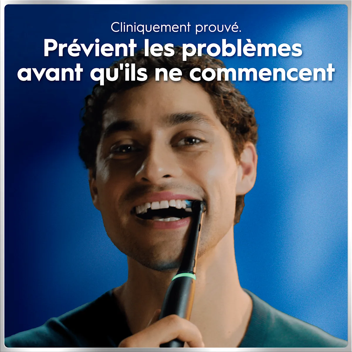 Personne souriante avec brosse à dents sur fond bleu. Texte: "Cliniquement prouvé. Prévient les problèmes avant qu'ils ne commencent"