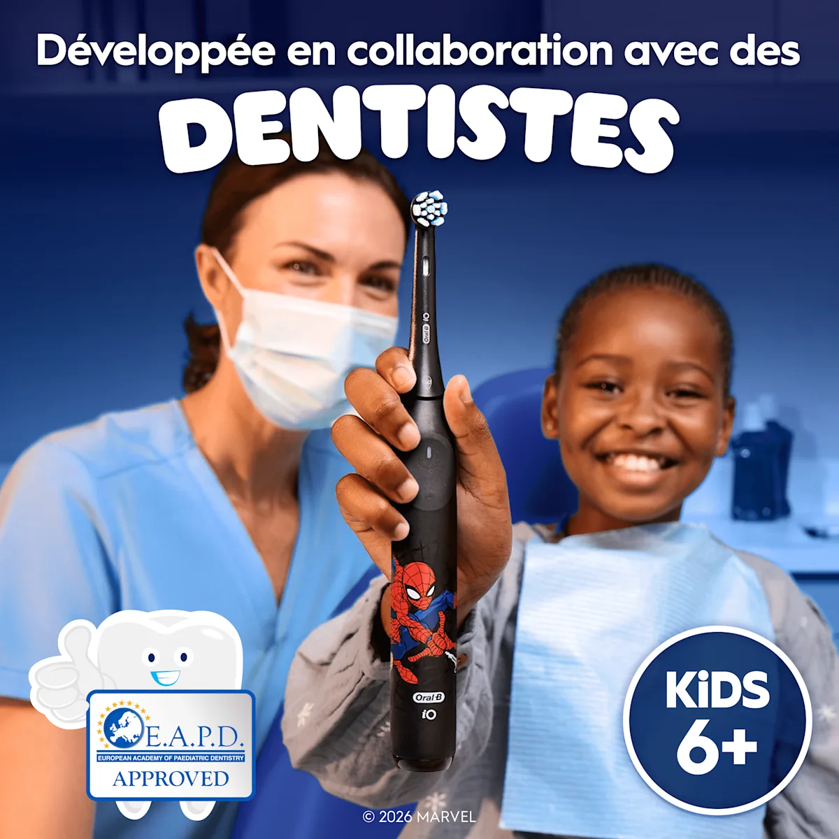 Un dentiste et un enfant tenant une brosse à dents iO Kids 6+, conçue avec des dentistes.