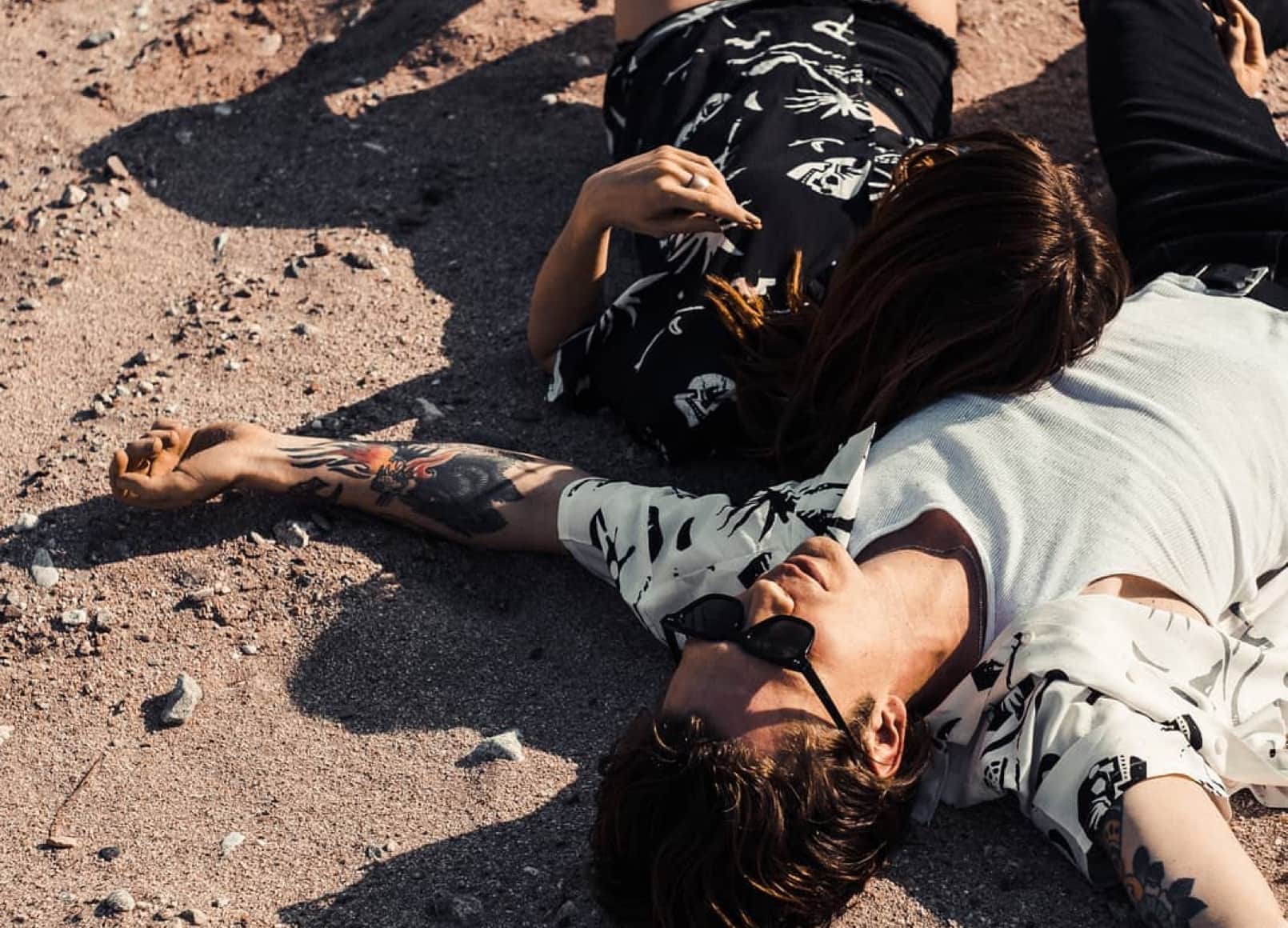 Two models lay sprawled out on a dirt road