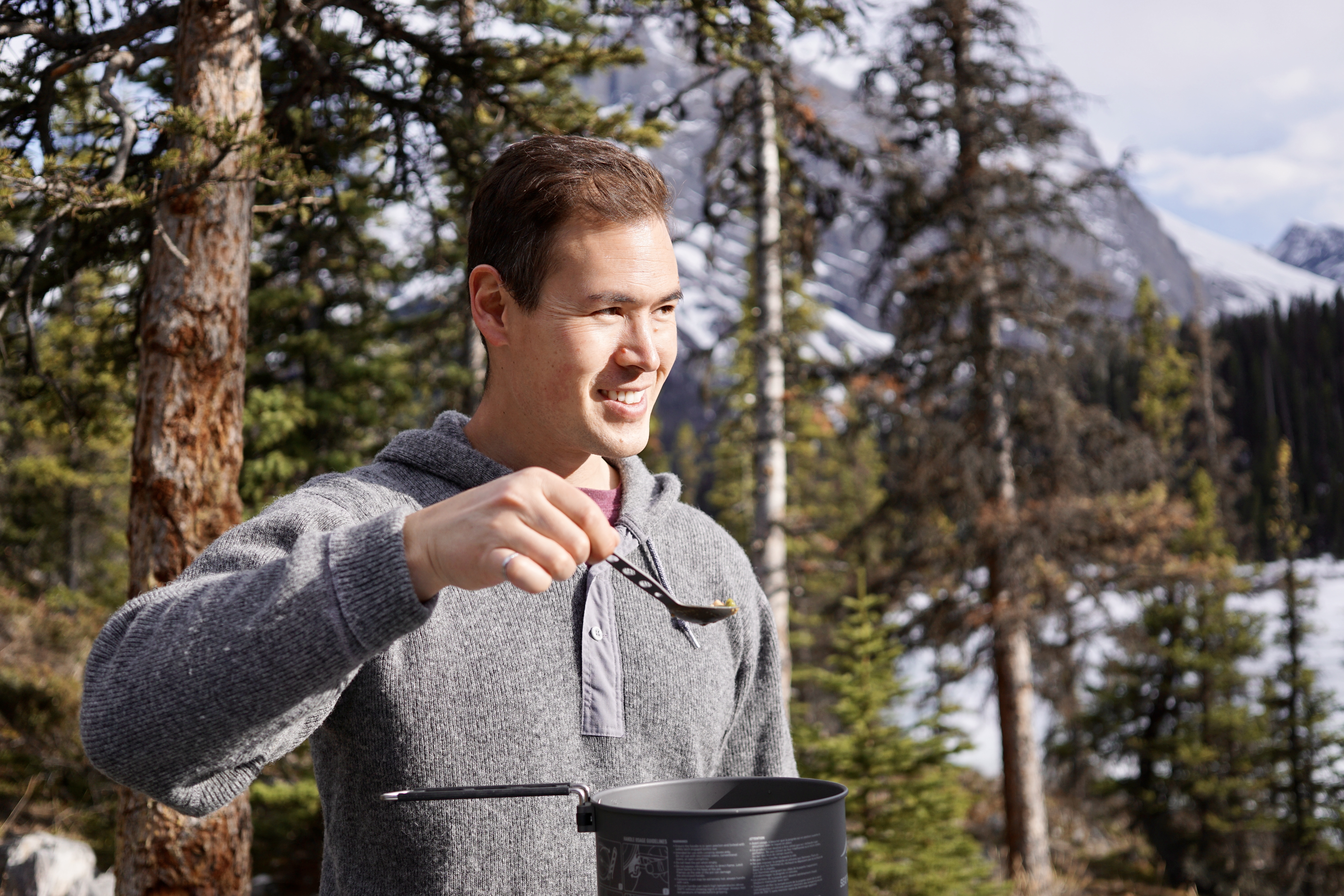 Man in sweatshirt cooking outdoors