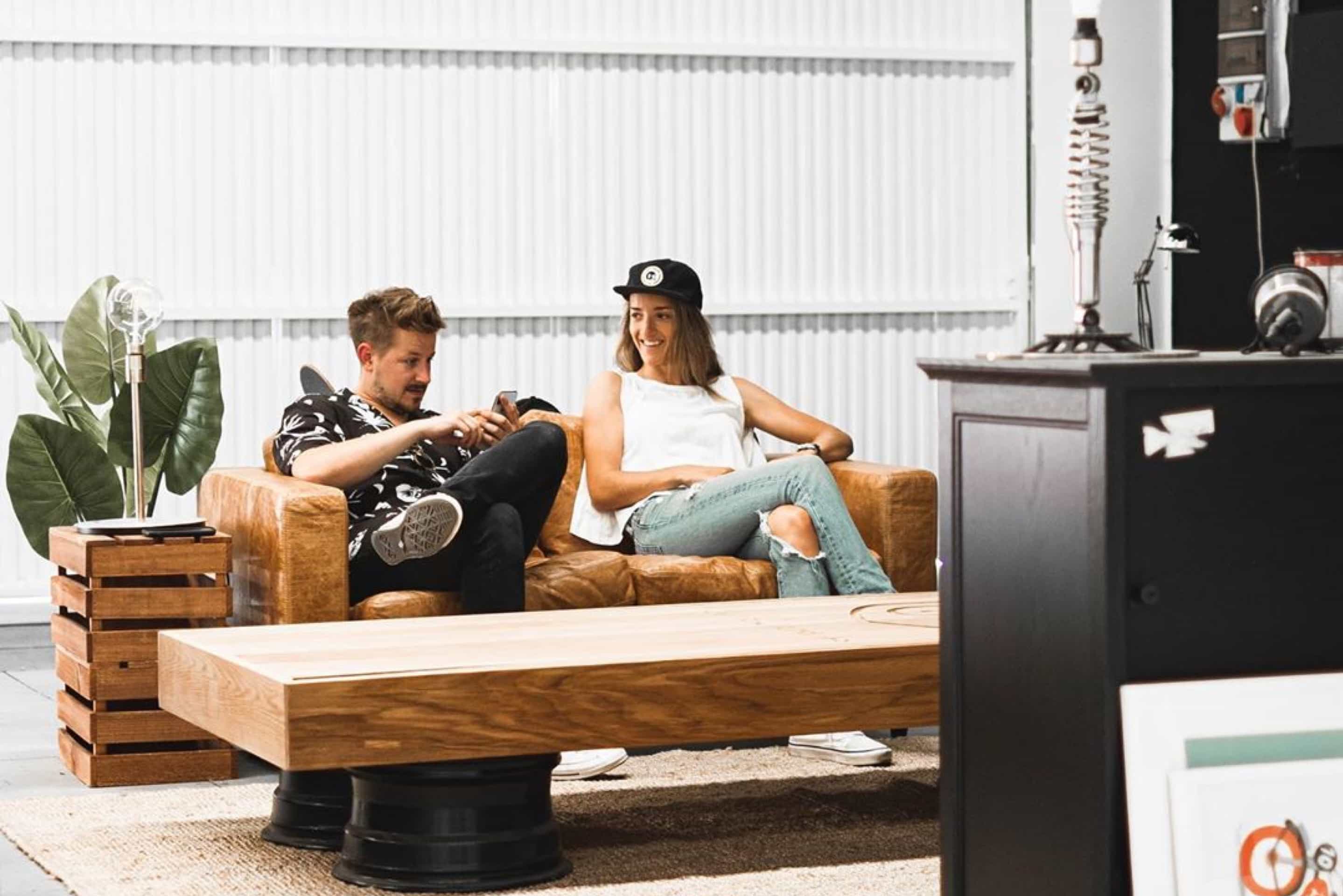 Two people sitting on a sofa are engaged in a lively discussion