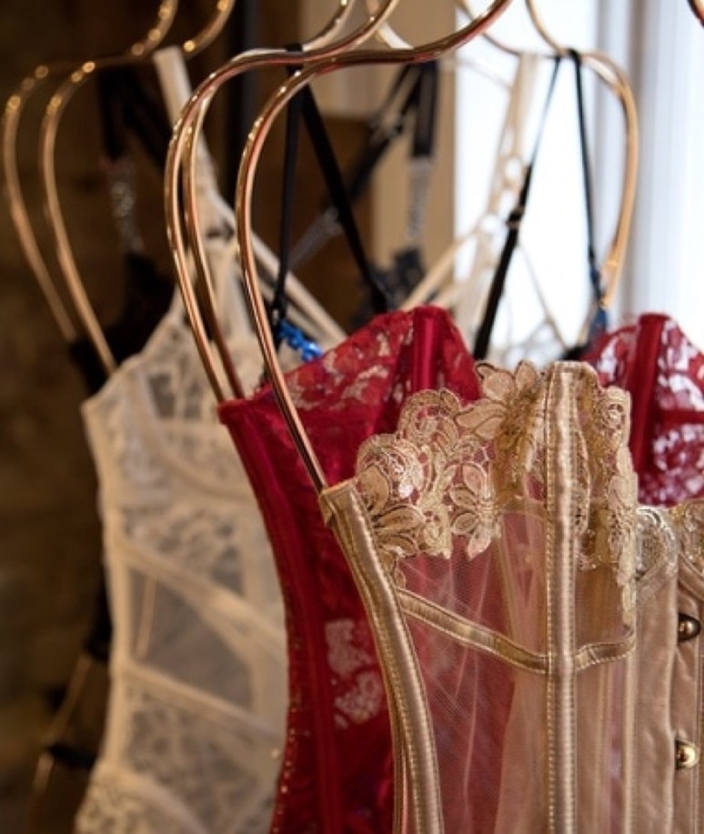 Several pieces of delicate lace lingerie hanging on a clothing rack.