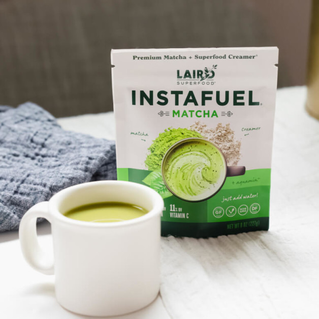 A Laird Superfood package for Matcha sits beside a cup with the Matcha mixture in a drink