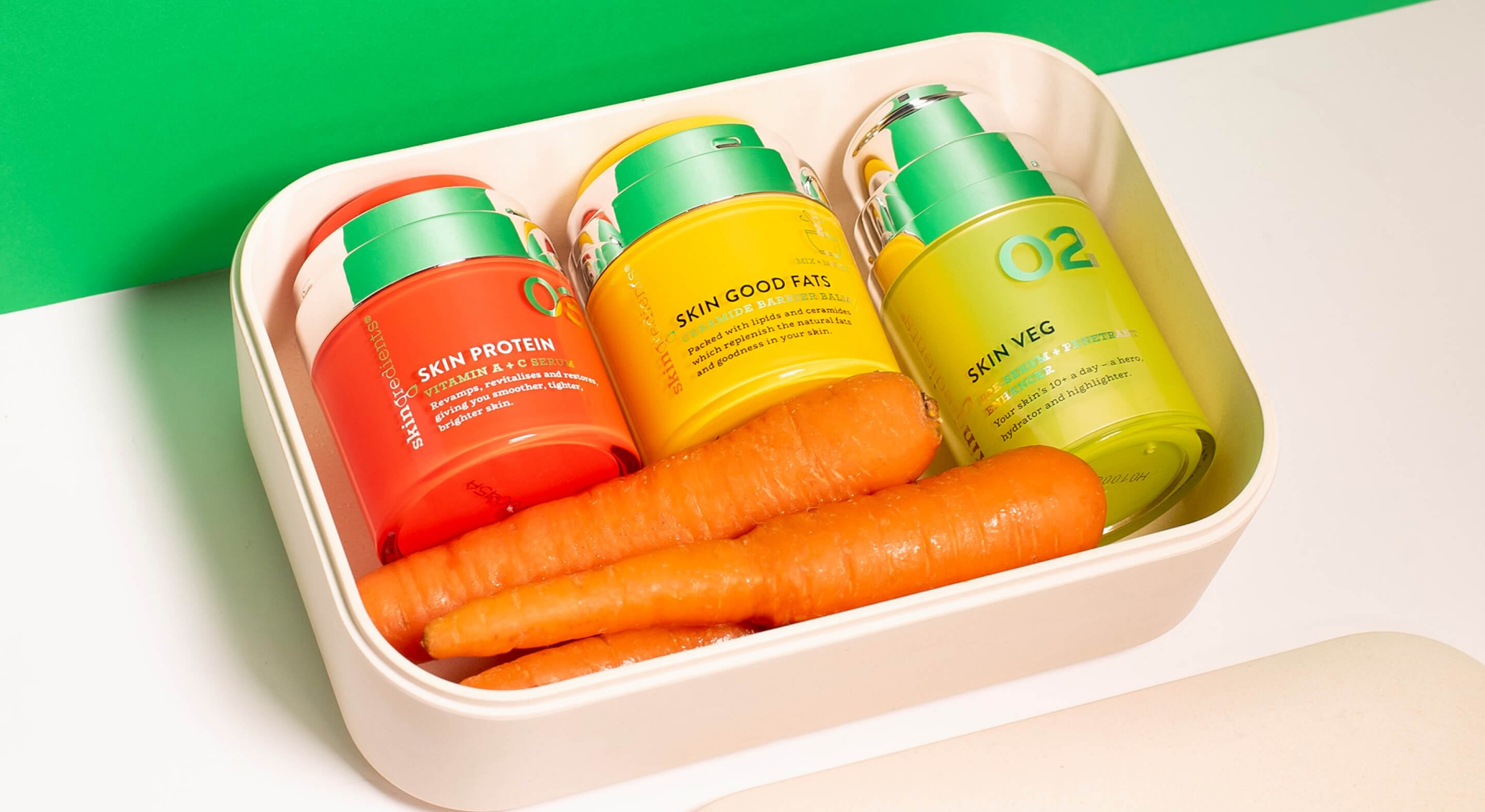 Three vibrantly coloured Skin Nerd products packed in a lunch box with some fresh carrots.