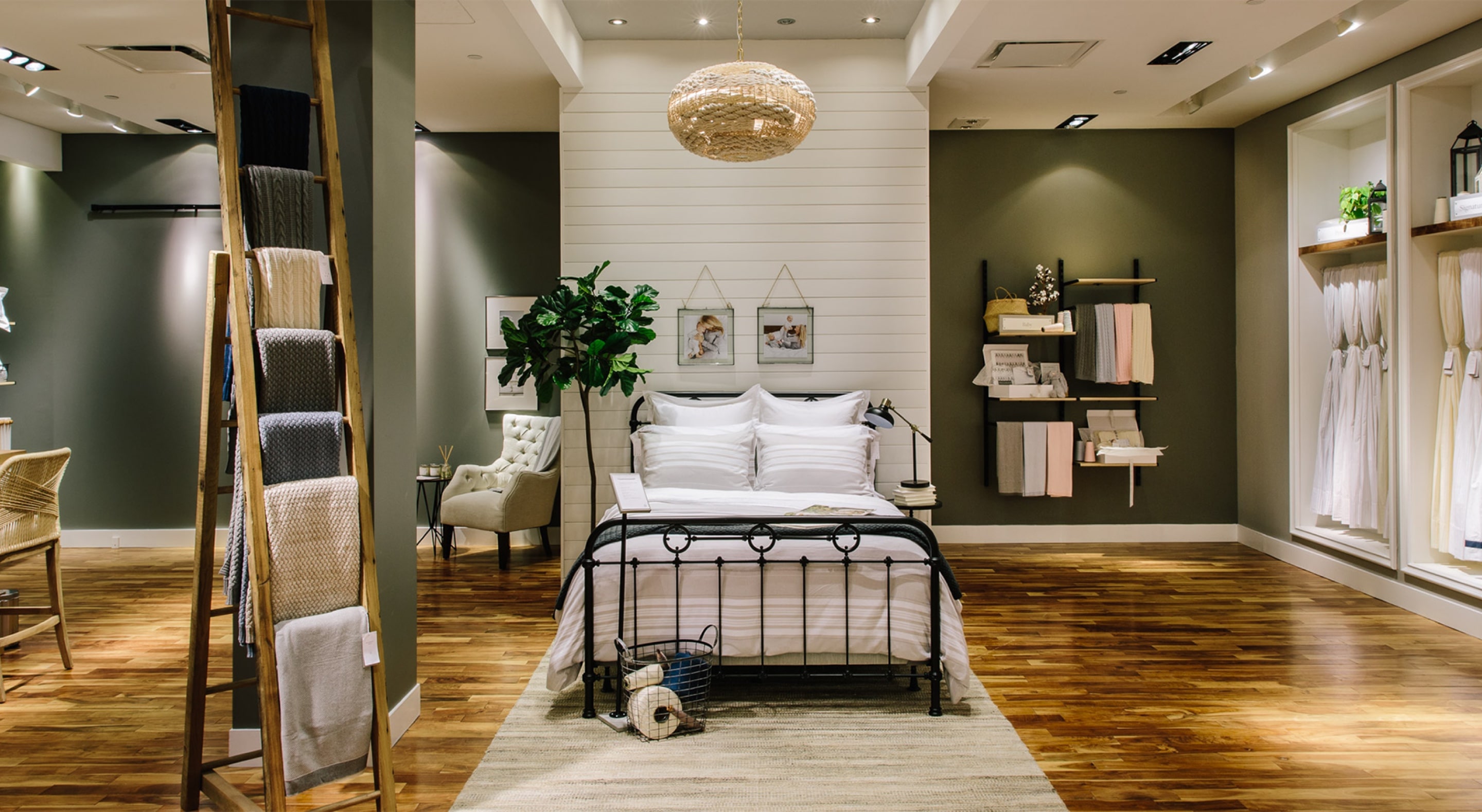 A Boll & Branch showroom, with hardwood floors throughout and a crisply-made bed at center