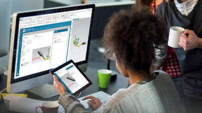 a women uses her tablet to connect to her computer to look at Enginering specs.